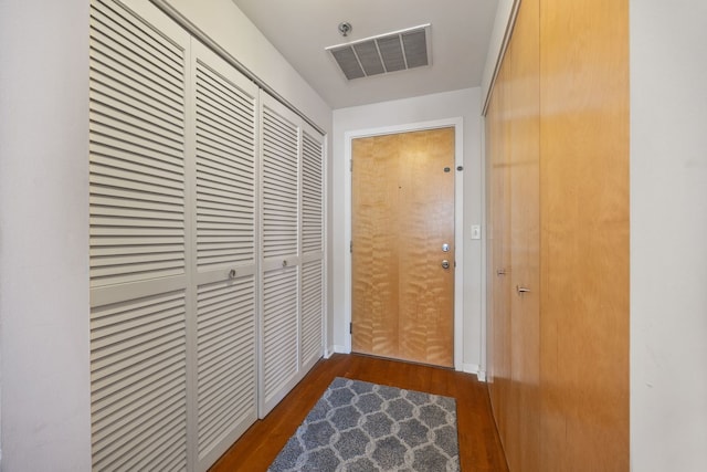 corridor with visible vents and wood finished floors