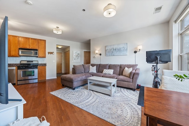 living room with baseboards, dark wood finished floors, and visible vents