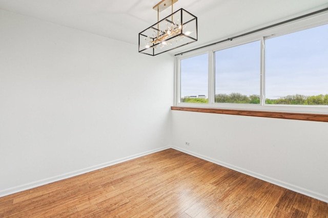 101 Bar Harbour Rd Unit 6N, Schaumburg, IL 60193 - unfurnished room with a chandelier, baseboards, and light wood-style floors