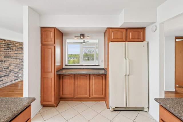 101 Bar Harbour Rd Unit 6N, Schaumburg, IL 60193 - kitchen featuring freestanding refrigerator, dark stone counters, brown cabinets, and ceiling fan