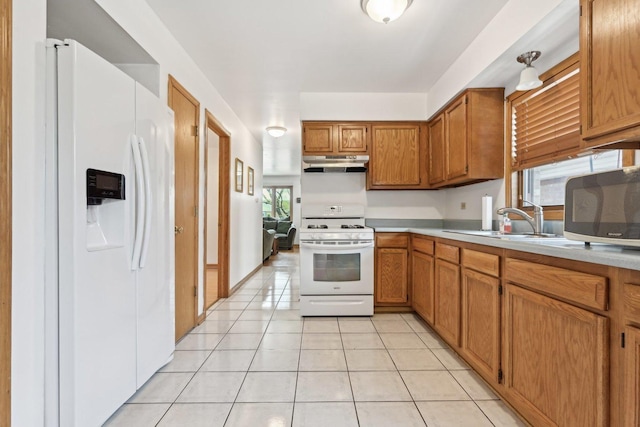 2740 W 35th Pl, Chicago, IL 60632 - kitchen with white appliances, under cabinet range hood, light countertops, brown cabinetry, and a sink