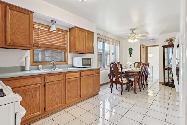 2740 W 35th Pl, Chicago, IL 60632 - kitchen with white microwave, light countertops, a sink, gas range oven, and light tile patterned floors