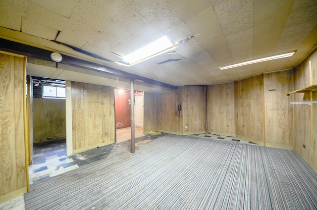 below grade area featuring wood walls and carpet