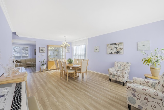 536 W Caldwell Dr, Round Lake, IL 60073 - dining space with ornamental molding, a notable chandelier, light wood finished floors, and plenty of natural light