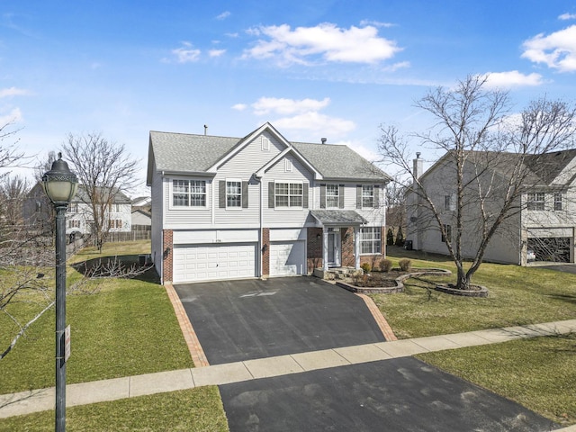 536 W Caldwell Dr, Round Lake, IL 60073 - traditional-style house with an attached garage, brick siding, a front yard, and aphalt driveway
