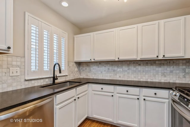 34309 N Goldenrod Rd, Round Lake, IL 60073 - kitchen with appliances with stainless steel finishes, a sink, dark countertops, and white cabinetry