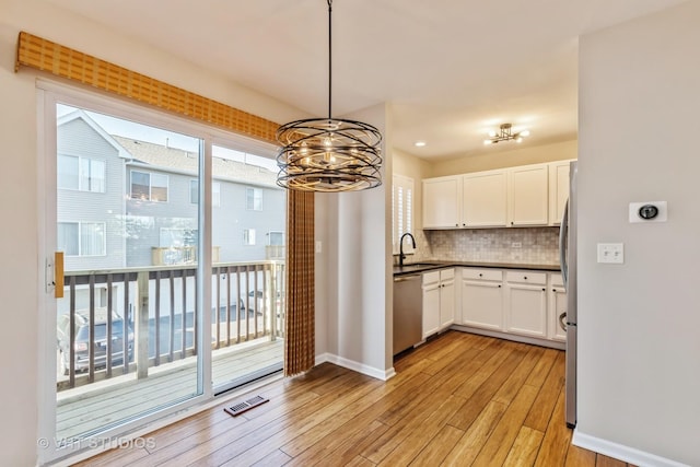 34309 N Goldenrod Rd, Round Lake, IL 60073 - kitchen featuring stainless steel appliances, a sink, light wood-style floors, a chandelier, and white cabinetry