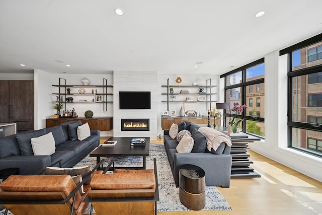 living room featuring wood finished floors, a fireplace, and recessed lighting