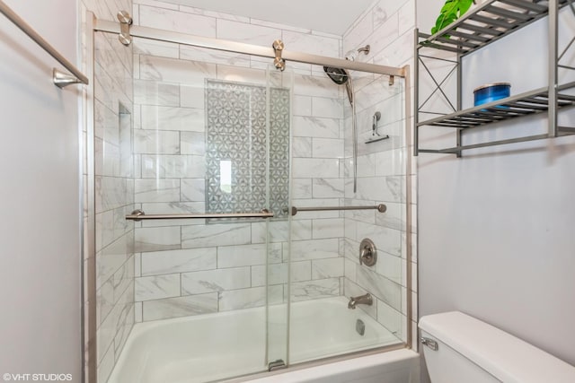 bathroom featuring toilet and combined bath / shower with glass door