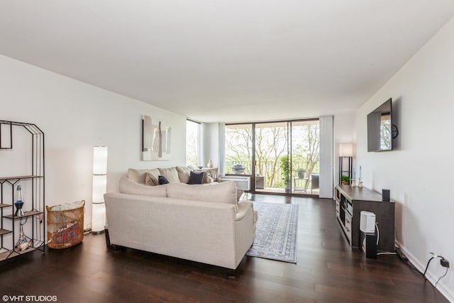 living room with dark wood-type flooring and floor to ceiling windows