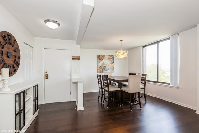 dining area featuring dark wood-type flooring and baseboards