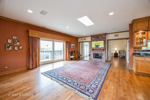 444 Ashland Ave Unit 5, River Forest, IL 60305 - living room featuring crown molding, a brick fireplace, light wood-type flooring, a skylight, and baseboards