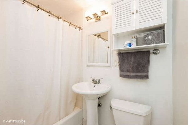 2930 N Sheridan Rd Unit 1008, Chicago, IL 60657 - bathroom featuring toilet and shower / bathtub combination with curtain