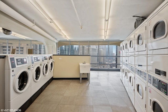 shared laundry area with baseboards, a view of city, washer and dryer, and stacked washer and clothes dryer