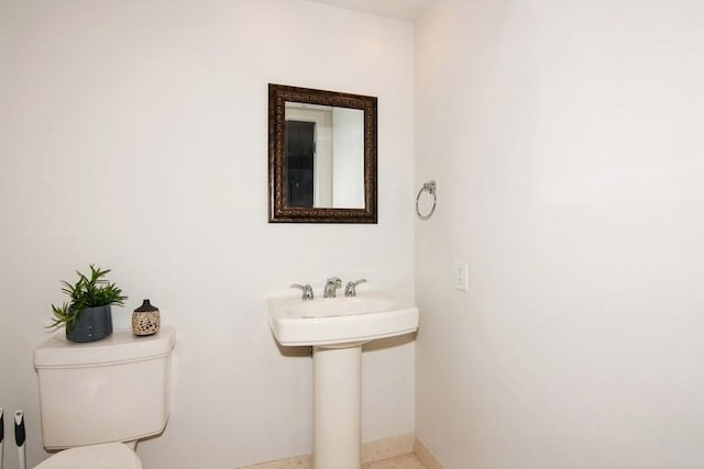 half bath featuring toilet, baseboards, and speckled floor