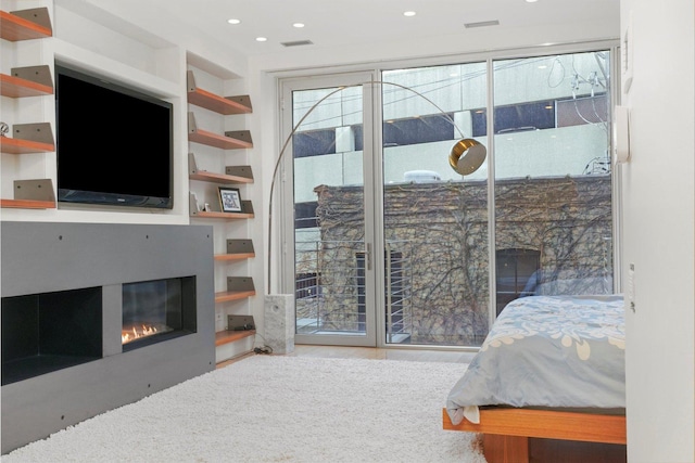 bedroom featuring recessed lighting, access to exterior, a glass covered fireplace, and visible vents