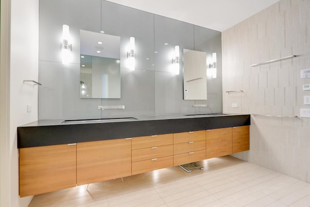 full bathroom with a sink, double vanity, and tile patterned flooring