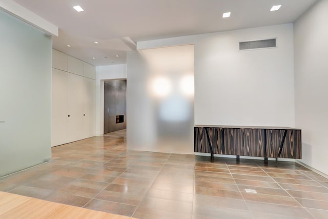 tiled empty room featuring recessed lighting and visible vents