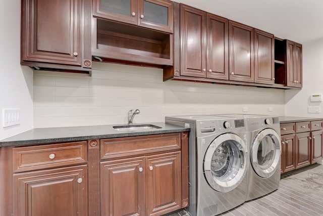 washroom featuring a sink, washing machine and dryer, and cabinet space