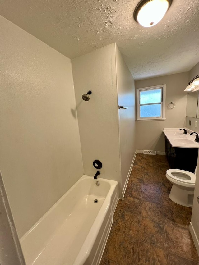 full bath with a textured ceiling, toilet, vanity, baseboards, and shower / bathtub combination
