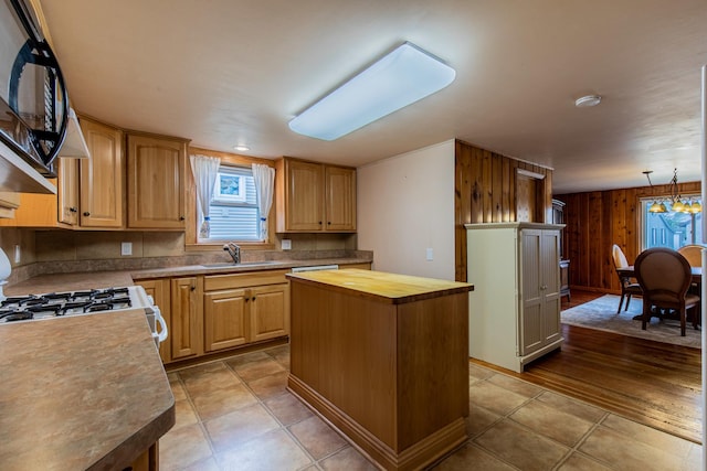 kitchen with a sink, wooden walls, wooden counters, and a wealth of natural light