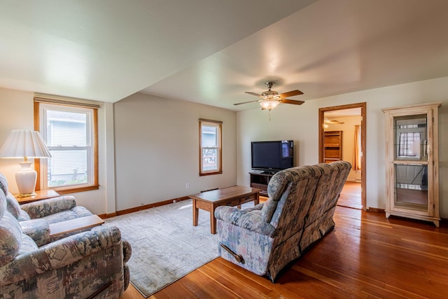 living room with wood-type flooring, baseboards, and ceiling fan