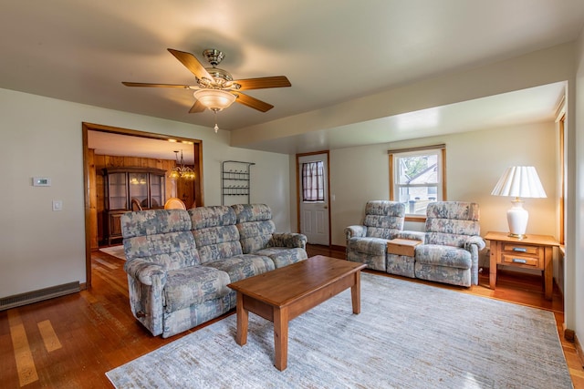 living area with baseboards, wood finished floors, and a ceiling fan