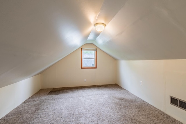 additional living space featuring vaulted ceiling, carpet, and visible vents