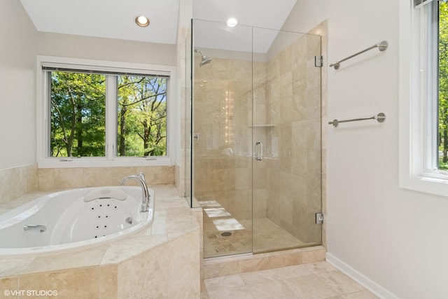 full bathroom featuring healthy amount of natural light, a jetted tub, a stall shower, and tile patterned flooring