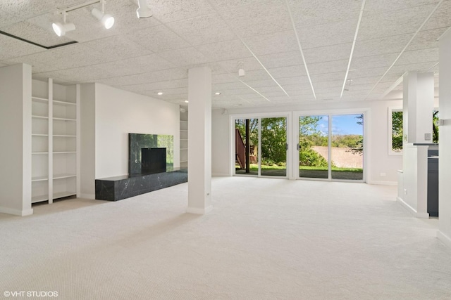 unfurnished living room with carpet flooring, a fireplace, and baseboards