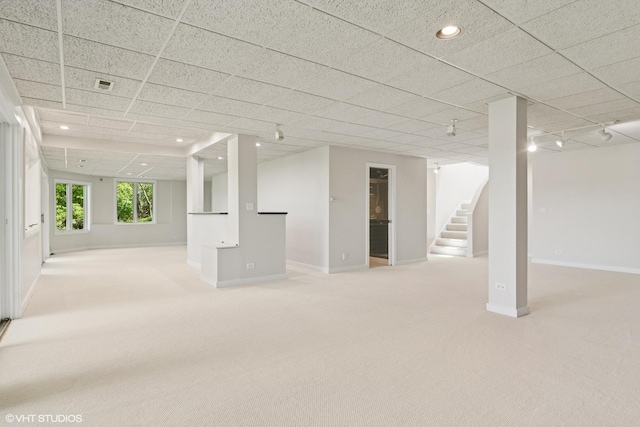 basement with light carpet, baseboards, stairs, and recessed lighting