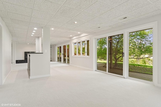 below grade area with carpet floors, baseboards, recessed lighting, and a drop ceiling