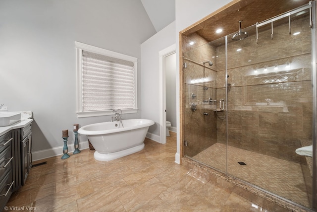 full bathroom with baseboards, toilet, a shower stall, vanity, and a freestanding bath