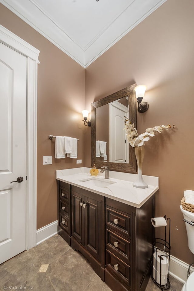 bathroom with baseboards, ornamental molding, vanity, and toilet