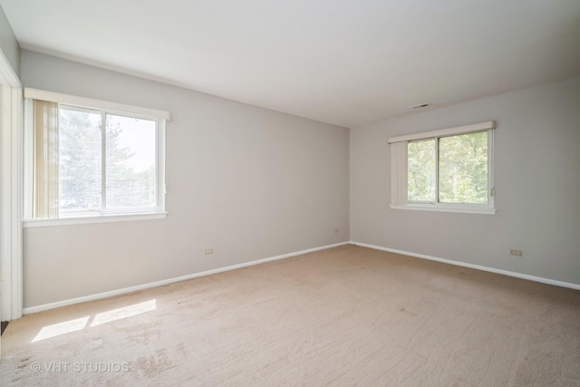 carpeted empty room featuring baseboards
