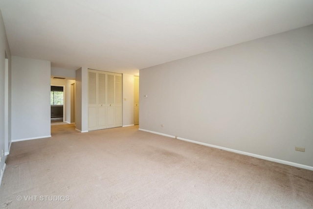 empty room with light colored carpet and baseboards