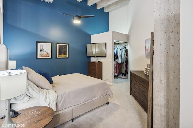 bedroom featuring a closet, ceiling fan, high vaulted ceiling, a walk in closet, and light carpet