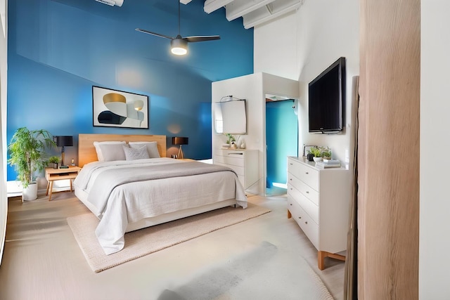 bedroom with light carpet, a towering ceiling, and a ceiling fan