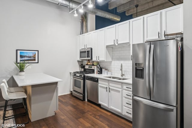 kitchen with light countertops, decorative backsplash, appliances with stainless steel finishes, and a sink