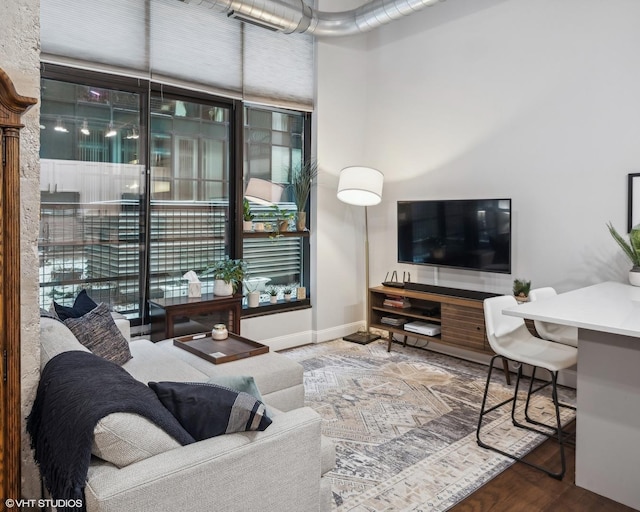 living area with baseboards and wood finished floors