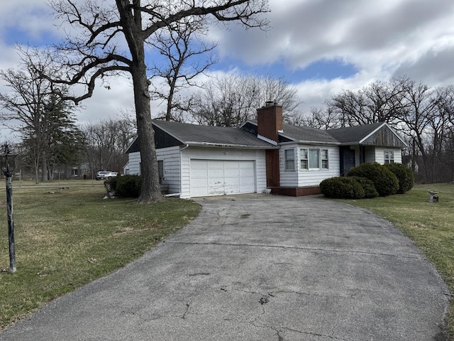 view of front of property with a chimney, a front lawn, aphalt driveway, and a garage