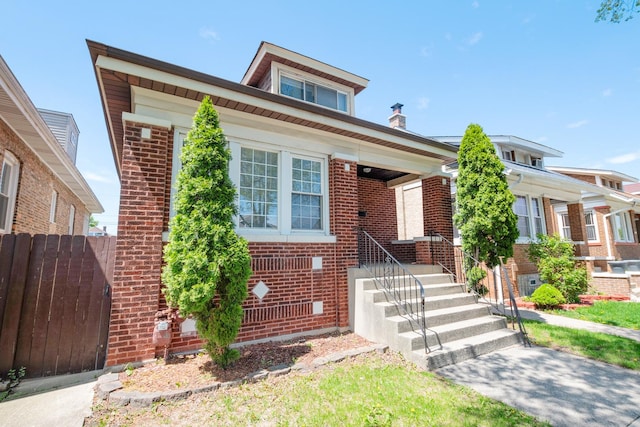 view of front of home with brick siding and fence