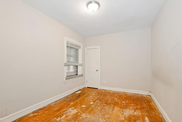 unfurnished room featuring baseboards and hardwood / wood-style floors