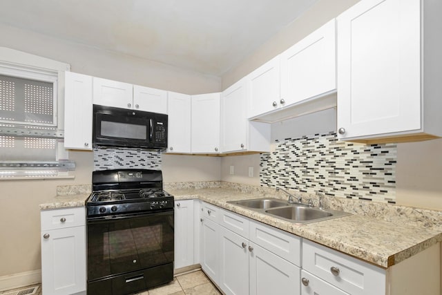 kitchen with black appliances, a sink, light countertops, and decorative backsplash