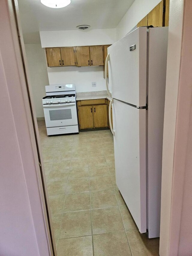 7202 W Crain St, Niles, IL 60714 - kitchen with light tile patterned floors, brown cabinets, white appliances, and light countertops