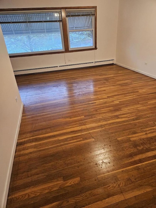 7202 W Crain St, Niles, IL 60714 - empty room with baseboards, wood finished floors, and a baseboard radiator