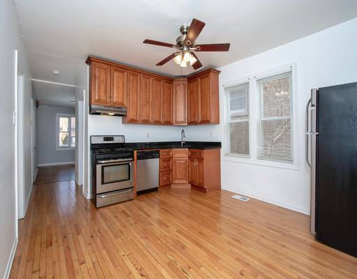 kitchen featuring under cabinet range hood, brown cabinetry, light wood finished floors, ceiling fan, and stainless steel appliances