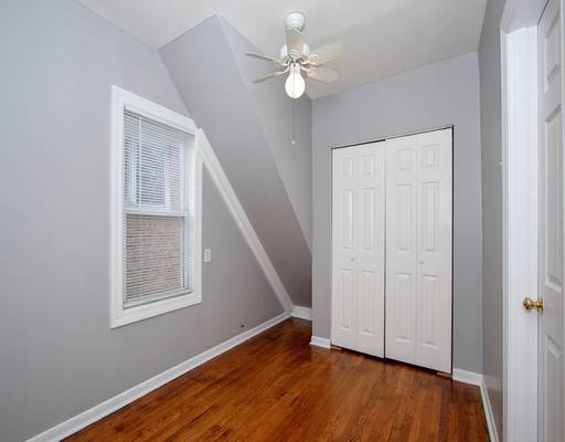 unfurnished bedroom featuring lofted ceiling, a closet, baseboards, and wood finished floors