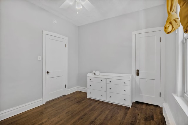 bedroom with baseboards, dark wood-type flooring, a ceiling fan, and a baseboard heating unit