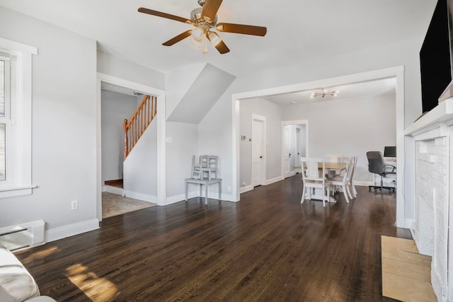 living room featuring wood finished floors, a ceiling fan, baseboards, a baseboard radiator, and stairs